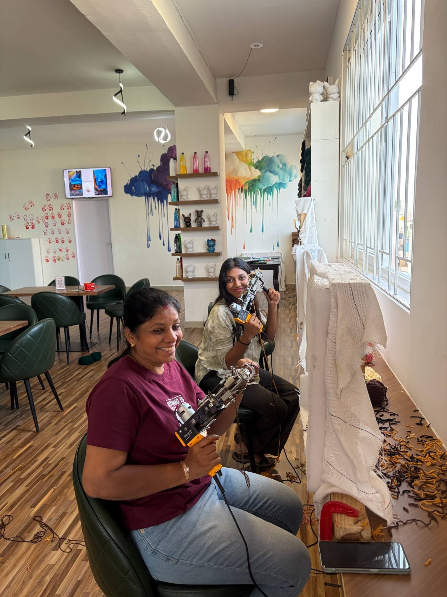 Two guests holding tufting guns at a Splashit tufting workshop
